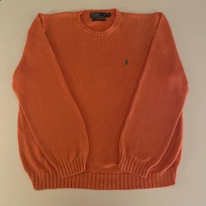 Orange stickad tröja från Polo Ralph Lauren - Säljer en snygg orange stickad tröja från Polo Ralph Lauren med det trendigaste märket på bröstet. Tröjan är i mycket bra skick och riktigt snygg