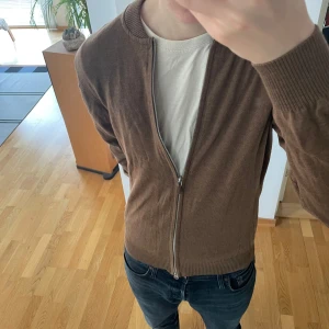 Stenströms Merino Full Zip Cardigan - Säljer en sjukt fet brun/beige Full Zip cardigan från stenströms. Nypris ligger på 2299 och den är i 100% Merino Ull. Tröjan är i toppskick sitter i storlek M men kan även passa S. Priset är ej hugget i sten!! Hör gärna av er vid frågor eller funderingar!