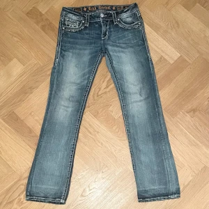 Vintage Rock Revival #29 - Snyggt slitna Rock Revival jeans i mellanblå.  Mjuka och sköna. Modell Beliss Bootcut Stl. 29 Mått Midja ca. 39/78cm Innerben ca. 80cm Ytterben ca. 103cm Vidd nedtill ca. 21cm 