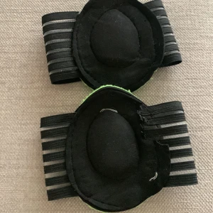 Strutz Cushioned Arch Supports - Säljer ett par Strutz Cushioned Arch Supports. De är svarta med gröna detaljer och har en bekväm kompressionsband för att ge maximalt stöd och perfekt passform. Perfekta för att absorbera stötar och ge komfort hela dagen. Tillverkade i slitstarkt och andningsbart material. Perfekta för alla typer av skor!