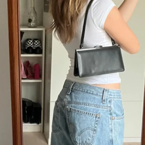  liten handväska - Svart liten handväska. Passar bra till bal eller fina sittningar för mobil nyckel och läppglans! Minifack innuti