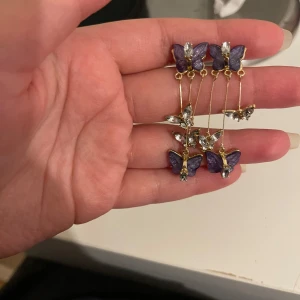 Lila fjärilsörhängen med gulddetaljer - Superfina örhängen med lila fjärilar och gulddetaljer.