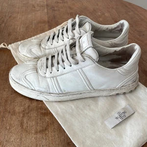 Valentino Flycrews - Vita Valentino Flycrews. De är i storlek 41 som man ser på bild tre, men är lite stora i storleken så sitter som storlek 42. Lite smutsiga men rena med en tvätt (därmed lågt pris). 14 nitar kvar. Dustbag ingår som man ser på första bilden. 