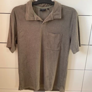 Olivgrön pikétröja från Firefly - Säljer en snygg olivgrön Frottépiké  från Firefly i storlek XS. Tröjan har en klassisk krage och en praktisk bröstficka. Perfekt för en avslappnad stil, oavsett om du ska på en sommarfest eller bara hänga med vänner.
