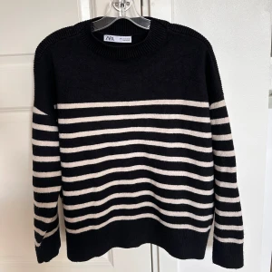 Svart och vit randig tröja från Zara - Säljer en snygg svart och vit randig tröja från Zara. Den är perfekt för både höst och vinter med sina långa ärmar och mjuka material. Tröjan har en klassisk rund hals och är i nyskick. Passar perfekt till jeans eller kjol för en stilren look!