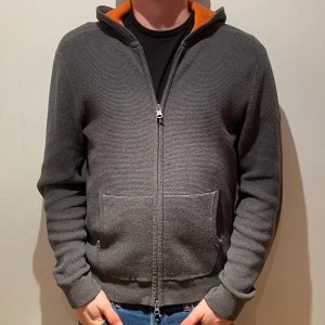 J.Lindeberg cardigan - Sjukt fet och sällsynt cardigan från j.Lindeberg. Med den orangea luvan får den en unik utstickande design! Skick: (10/10)🎯. Vid köp av våra produkter får du även med tre par brillor (se sista bild)🌏🌏 MVH// VALENCO