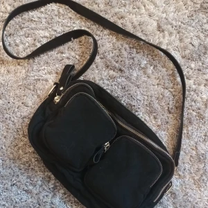 Noella liknade väska - Svart noella liknande väska från gina, inga deffekter o endast använd 1 gång. Många bra fack i väskan och man får även till ett kort band som man kan se på någon av bilderna. Köpt för 349 kr
