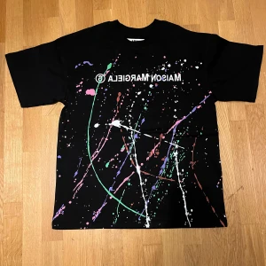 Maison Margiela T-shirt paint - Säljer den här Maison Margiela T-shirten i svart med paintsplash. Den är i storlek S men passar M. Perfekt skick. Passformen är ganska baggy