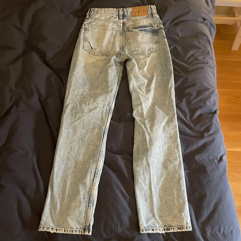 Säljer ett par snygga 90's boyfriend jeans. De är högmidjade och har en avslappnad passform. Jeansen är ljusblå med slitningar på framsidan som ger en cool, vintage look. Perfekta för en casual outfit!. Jeans & Byxor.