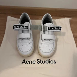 Acne Studios Trainers - Brand new Acne Velcro sneakers size 38 RRP 5500 sek Velcro sneakers feature an 80s tennis trainers-inspired construction, crafted from leather and detailed with a Face logo animation. - Round toe sneakers - Velcro closure - Face logo detalling