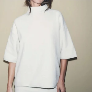 Vit polotröja med trekvartsärm - Säljer en stilren vit polotröja med trekvartsärm. Perfekt för en minimalistisk look och passar bra till både jeans och kjol. Tröjan har en lös passform och är gjord i ett mjukt material för extra komfort.