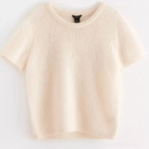 Vit stickad tröja från Lindex - Mysig vit stickad tröja från Lindex med korta ärmar. Perfekt för lager-på-lager under kyligare dagar. Tröjan har en rund halsringning och en mjuk textur. En liten fläck på utsidan av vänster arm men inget som man lägger märke till. Nypris 600💞