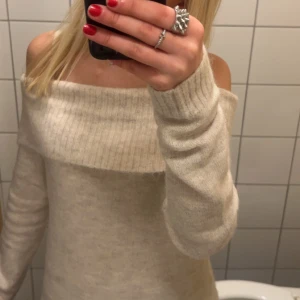 Beige offshoulder tröja - Säljer en stilren beige offshoulder tröja med långa ärmar. Perfekt för en avslappnad och trendig look. Tröjan är mjuk och bekväm, idealisk för kyligare dagar.