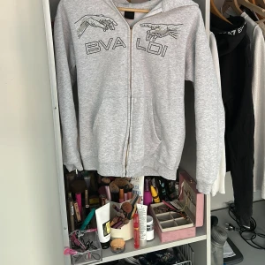 grå tröja från bvaldi  - Snygg grå hoodie från Bvaldi med glittrande strassdetaljer på framsidan. Tröjan har en dragkedja och en bekväm huva. Gillar verkligen tröjan men tyvärr kommer inte till användning.tvättas givetvis innan jag skickar iväg, i superfint skick förutom att dragkedjan har jag tappat med funkar att dra upp och ner precis som vanligt. annars är allt som de ska och inga defekter. köpt på bvaldi i väla för 1100 men säljer för 400. kan sänka vid snabb affär. skriv vid frågor