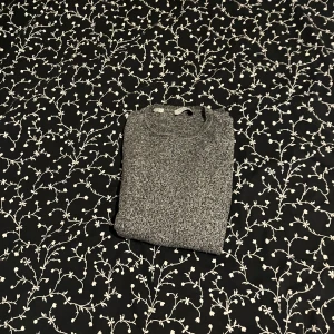 Grå stickad tröja - Säljer en grå stickad tröja från Selected Homme. perfekt för kyligare dagar. Den är i en snygg melerad grå färg som passar till det mesta. 