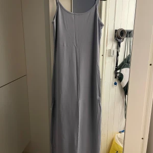 ljusblå långklänning från Pull&Bear - Säljer en stilren ljus blå långklänning från Pull&Bear. Klänningen har smala axelband och en enkel design som passar perfekt för en minimalistisk look. Perfekt för varma dagar eller som en bas i garderoben.
