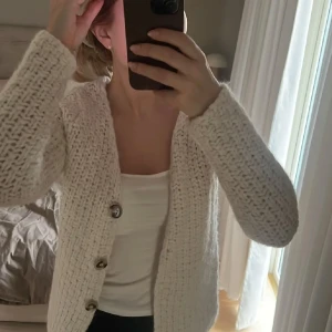 Vit stickad kofta från Zara - Säljer en mysig vit/kräm stickad kofta från Zara med knappar framtill. Finns inte längre att köpa! 