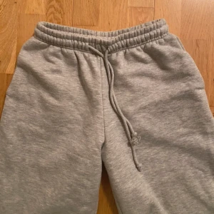 Grå mjukisbyxor med snörning - Säljer ett par bekväma grå mjukisbyxor med elastisk midja och snörning. Perfekta för en avslappnad stil.