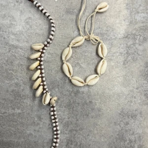 Halsband och armband med snäckor - 2 stycken armband men som också kan användas som fotlänk, dekorerade med vita snäckor.