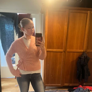 Rosa omlottkofta från & Other Stories - Säljer en söt rosa omlottkofta från & Other Stories. Koftan har ett fint mönster och knytband i midjan. Perfekt för en mysig dag eller en stilren look. 💖