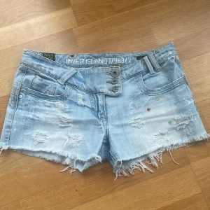 Ljusa jeansshorts från River Island - Unika och snygga jeansshorts med en avslappnad stil. Köpt av en annan tjej här på Plick men passade tyvärr inte! 💗 Märket är River Island och i står storleken 36. 40 cm rakt över. Dom är lågmidjade och har fina detaljer 💗💗Skriv vid mer frågor!