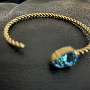 Guldarmband med kristaller från Caroline Svedbom 18k guldplaterad  - Eleganta guldarmband från Caroline Svedbom med vriden design och stora kristaller i olika färger. Perfekt för att ge en touch av glamour till din stil. Finns i blå, rosa och klara kristaller.