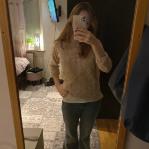 Beige stickad tröja - Säljer en mysig beige stickad tröja med ett vackert mönster. Tröjan har långa ärmar och en normal passform, perfekt för kyligare dagar. Den är både stilren och bekväm, idealisk för höst och vinter.