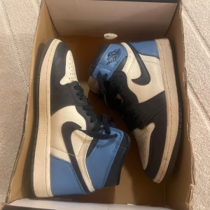 Air Jordan 1 Retro High OG Obsidian Strl 38 - Säljer ett par Air Jordan 1 Retro High OG “Obsidian” i storlek 38 (EU) / UK 4.5 / US 7W. Skorna är använda 2 gånger men i bra skick, med normalt slitage på sulan och ovandelen (se bilder för skick). Bekväma och stilrena sneakers som passar både till vardags och streetwear. Finns för upphämtning i Stocholm eller kan skickas. Om man vill ha lite fler bilder är det bara att skriva till mig. Vita skosnören kommer med.