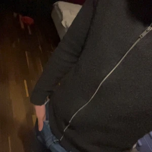 Grå Svart kofta med dragkedja i bomull  - Säljer en stilren svart kofta med dragkedja. Perfekt för kyligare dagar och enkel att matcha med olika outfits. Koftan har långa ärmar och en bekväm passform.