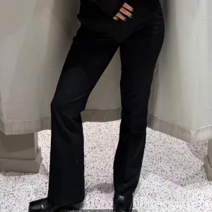 Svarta kostymbyxor från bikbok st 38 - Eleganta svarta kostymbyxor med  hög midja och bootcut-stil. Perfekta för en stilren look. Byxorna har en klassisk design med dragkedja och knappar framtill. Byxorna är använda men fortfarande i fint skick! Skriv för fler bilder då jag kan skicka en närmre bild på hur byxorna ser ut bedantill då dem kanske är lite slitna❤️‍🔥❤️‍🔥men de tänker man ej på