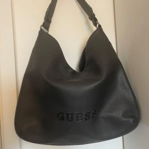 Svart axelväska från Guess - Aldrig använd,väldigt ren, inga defekter.