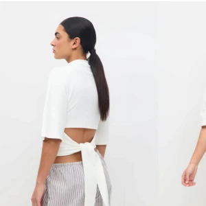 Vit knytblus - Snygg vit blus med knytning i ryggen och trekvartsärmar. Perfekt för en stilren look. Är storlek M men passar mig som bär xs-s, då man kan justera tröjan med banden. Helt ny 