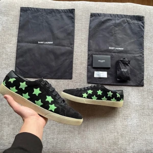 Yves Saint Laurent skor  - Säljer ett par svarta Yves Saint Laurent skor med gröna stjärnor ⭐️ | Modell: SL/06 | Storlek: 45 | Väldigt väldigt VÄLDIGT fint skick utan några defekter över huvudtaget! ~ Tillkommer 2 påsar, tackkort från YSL och extra skosnören med köpet | Nypris 7000kr, vårat 2475kr | Hojta till vid fundering 💭 