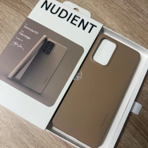 Beige mobilskal för Samsung A33 från Nudient - Aldrig använt! Endast öppnad för foto. Snyggt och stilrent mobilskal i färgen clay beige från Nudient, designat för Samsung A33. Det är ett tunt V3-skal som ger ett bra skydd utan att göra telefonen klumpig. Perfekt för dig som vill ha ett minimalistiskt och elegant skydd.