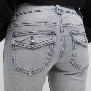 Snygga Grå jeans från Gina💗 - Köptes i början av Januari andvända 3 gånger💗Snygga grå jeans, lågmidjade med två bakfickor som har knappdetaljer. Jeansen har en klassisk passform och är perfekta för en stilren look, passar till allt! Säljes pga att de är för korta. Skulle säga att de passar nån som e runt 167-171!