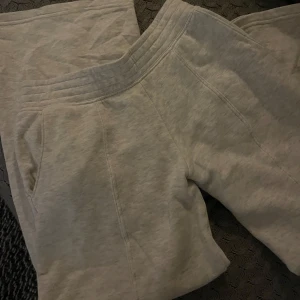 Lågmidjade mjukisbyxor - Säljer ett par bekväma grå lågmidjade mjukisbyxor med elastisk midja och sidfickor. Byxorna har en enkel och stilren design.