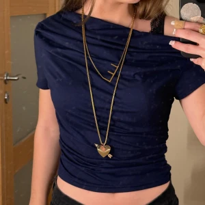 Mörkblå topp med korta ärmar - Snygg mörkblå topp med korta ärmar och en unik detalj vid halsen. St s!❤️ absolut inga tekniska på användning.