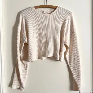 Ribbad tröja - Crèmevit ribbstickad tröja från Pull & Bear, nyköpt och helt oanvänd! Väldigt stilren och fräsch, passformen är relaxed och ärmarna är lite extra långa, materialet gör den även stretchig. Det är bara att skriva om du har några frågor! <3