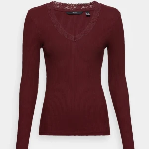 Vinröd ribbad topp från Vero Moda - Säljer en snygg vinröd ribbad topp från Vero Moda med spetsdetaljer vid v-ringningen. Toppen har långa ärmar. Knappt använd.💗💗