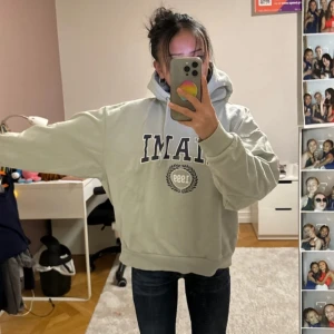 Grå hoodie med tryck - Säljer en grå hoodie med tryck framtill. Den har en klassisk design med en stor ficka på magen och en bekväm huva. Perfekt för en avslappnad stil.