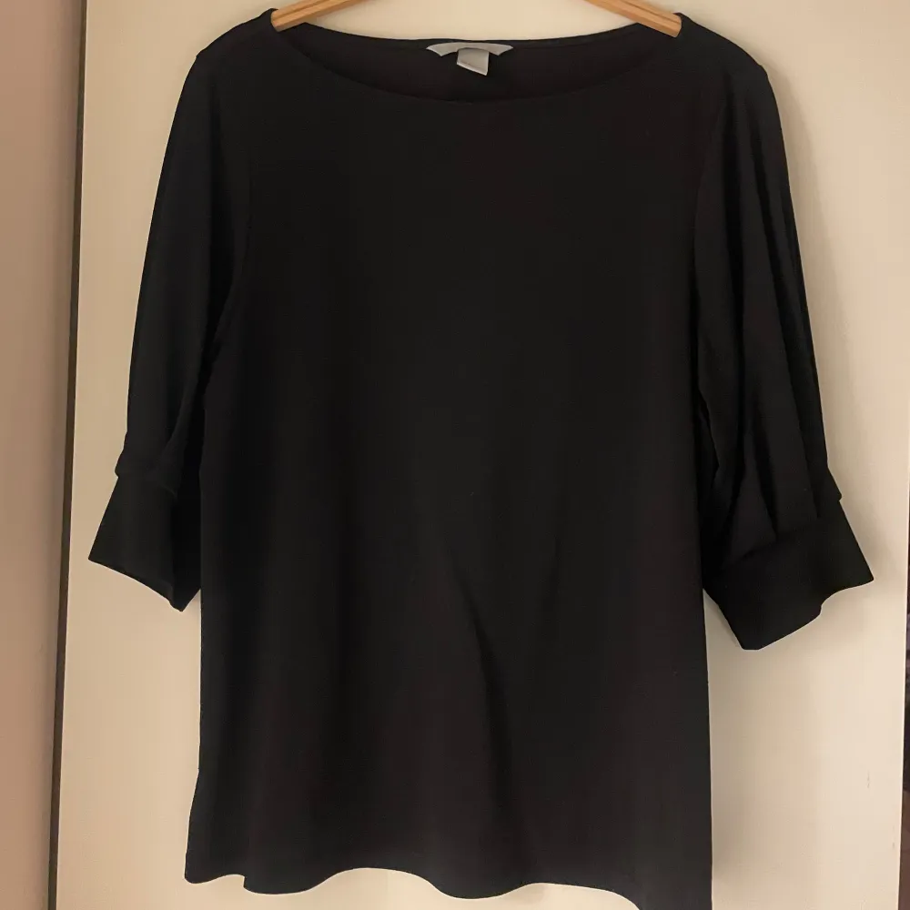Svart blus från H&M med trekvartsärm. Knappt använd. Puserot.
