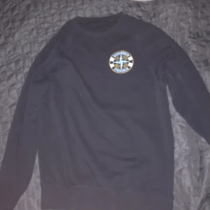 Svart tröja med Djurgården-emblem - Säljer en svart tröja med ett coolt Djurgården-emblem på bröstet. Tröjan har långa ärmar och en rund halsringning. Perfekt för alla Djurgården-fans! 💛❤️💋