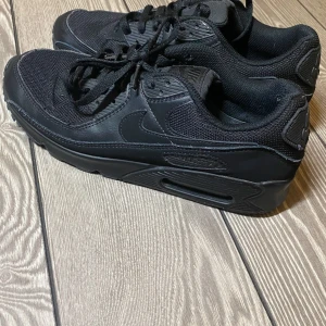 Nike Air Max  - Storlek 42, Snygga helsvarta Nike Air Max sneakers med klassisk design. Skorna har en luftig ovandel i mesh och slitstarka detaljer i syntet. Den ikoniska Air Max-dämpningen ger extra komfort. Perfekta för en stilren look.