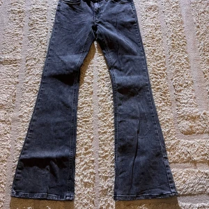 Low waist bootcut jeans - Snygga mörkgråa low waist bootcut jeans. Säljer då de tyvärr blivit för små. De är använda men i fint skick