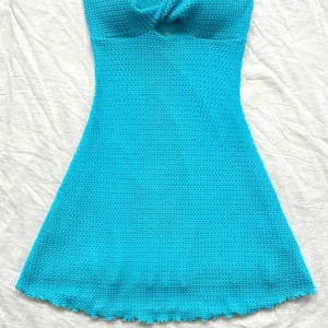 Turkos klänning med knutdetalj - Snygg turkos klänning med en unik knutdetalj framtill. Klänningen är använd en gång🩵