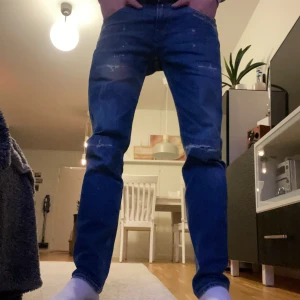 Replay Anbass - Snygga blå jeans från Replay med slitna detaljer och en klassisk femficksdesign. De har en dragkedja och knapp framtill. Perfekta för en avslappnad stil. Modellen är 180cm Modell på jeans: Anbass 29/30 nypris 1800kr