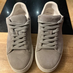 Grå mockasneakers - Snygga grå sneakers i mocka. Bra skick använda fåtal gånger. Storlek 41