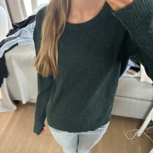 Mörkgrön tröja - Säljer en stilren mörkgrön tröja från Vila. Tröjan har en rund halsringning och långa ärmar. Perfekt för en avslappnad look, strl s💝