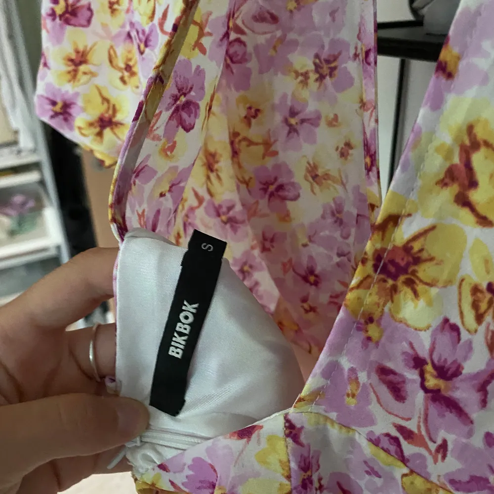 Säljer en superfin blommig klänning från Bik Bok i storlek S. Den har en vacker mix av rosa och gula blommor på en vit bakgrund. Klänningen är kortärmad och har en djup v-ringning. Perfekt för sommarens alla fester! Den har en dragkedja i ryggen för enkel påklädning.. Mekot.