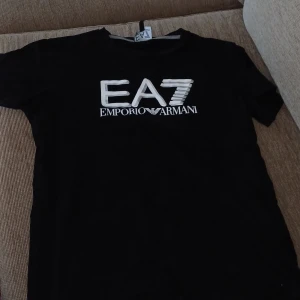 Emporio Armani T-shirt EA7 tryck - Säljer nu min Emporio Armani t-shirt för att den passar inte längre. Har använt den bara några enstaka gånger. Den har ett snyggt EA7 tryck i 3D. 